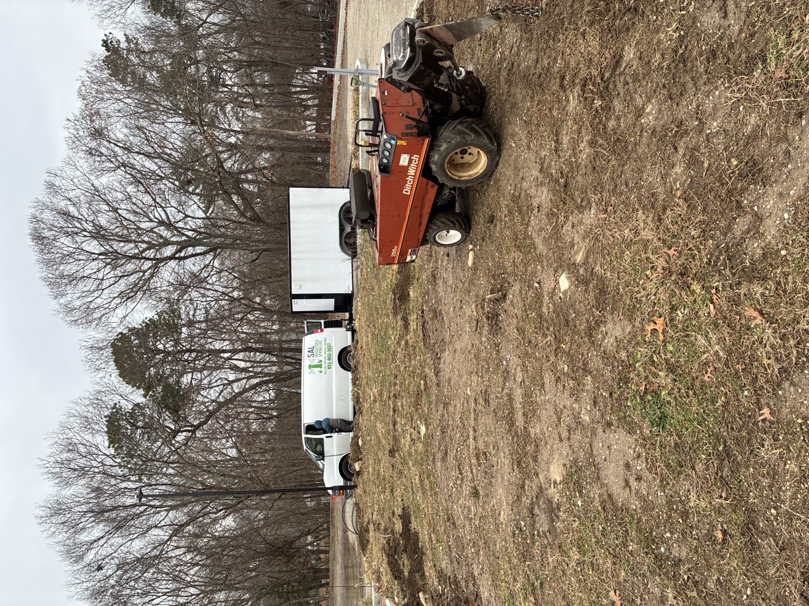 SAL Irrigation van, trailer, and trencher at a Long Island job site