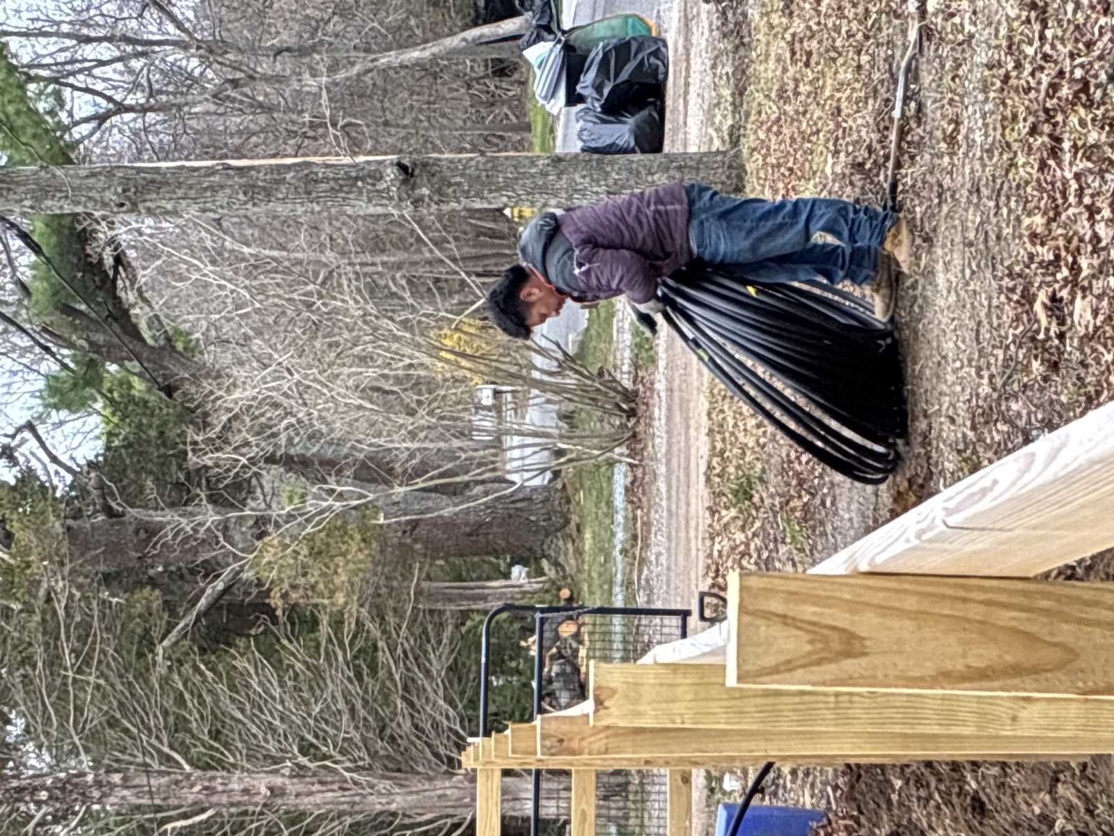 SAL technician laying irrigation tubing along a new fence line